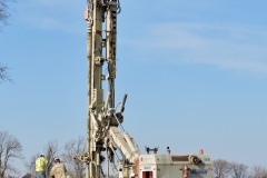 March 2021 - Workers drill a casing for a pile that will be used to support the embankment during construction of an abutment for the southbound U.S. 1 bridge over the Turnpike.